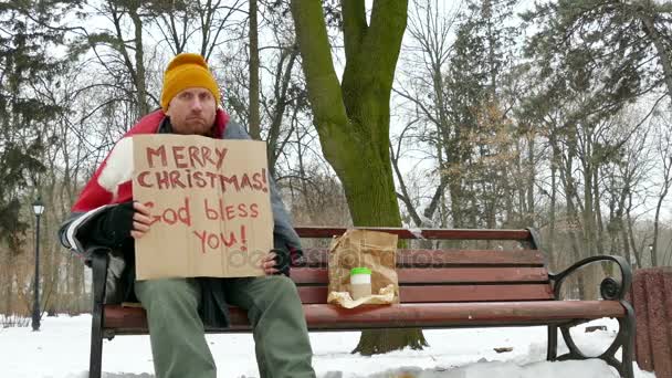 4 k. šťastný bezdomovec v zimě městského parku s lepenkové Veselé Vánoce — Stock video