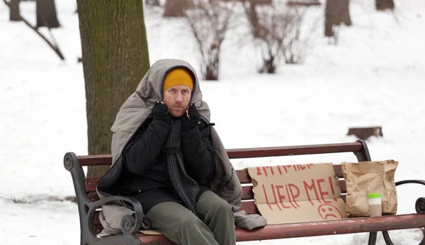 Hombre adulto sin hogar con cartulina se congela en invierno día de la ciudad —  Fotos de Stock