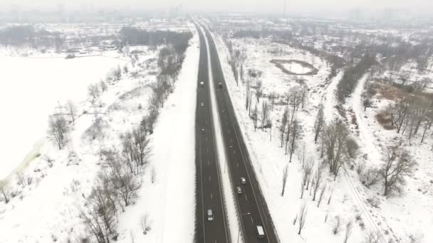 Aérea 4K. Sobre la ciudad de invierno carretera suburbio con coche en día nublado . — Vídeos de Stock