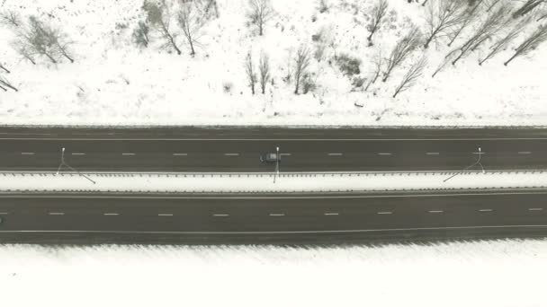 4k antenn. Förort highway med bil i molnig vinterdag. Laterala låg flygning — Stockvideo