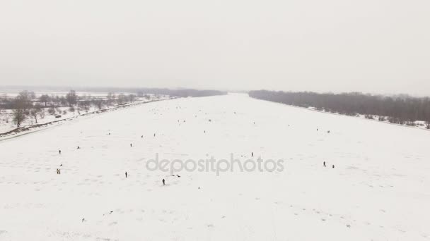 4k luchtfoto. Silhouet van winter fishermens over bevroren rivier — Stockvideo