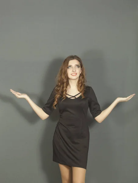 Ελκυστική νεαρή κοπέλα σε μαύρο φόρεμα με κρατά τα χέρια στα κόμματα — Φωτογραφία Αρχείου