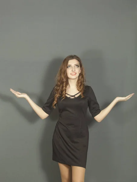 Attractive young girl in  black dress with  holds hands in  parties — Stock Photo, Image