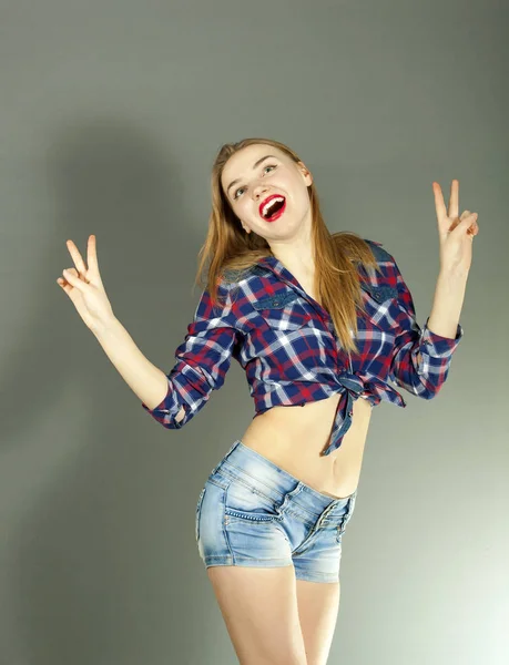 Молодая улыбающаяся эмоция сексуальная девушка в пинап стиле показать два пальца на сером фоне — стоковое фото