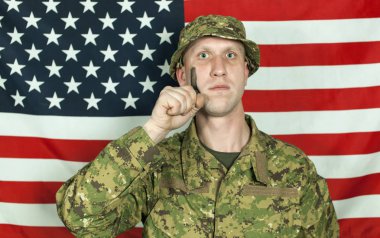 Kamuflaj Boya Amerikan bayrağı karşı yanağına genç asker. Portre
