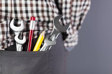  Wrenchs ve toos, sarı kalem pantolon hip cebinde. Kapatma iş adam simgesi kadar