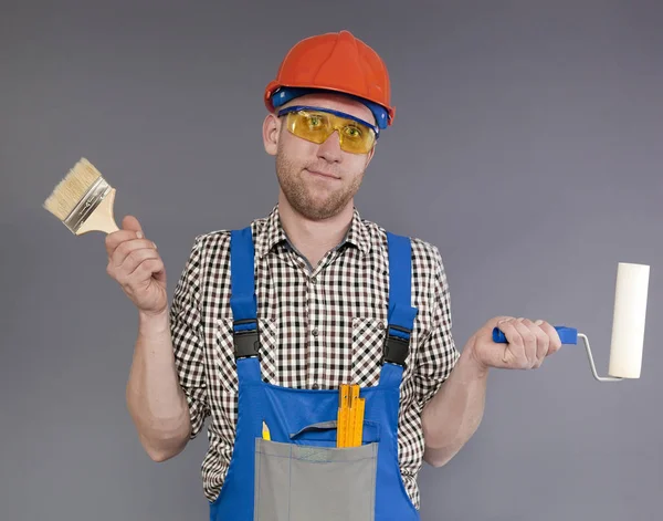 Étonné jeune peintre moderne stand avec brosse et rouleau — Photo