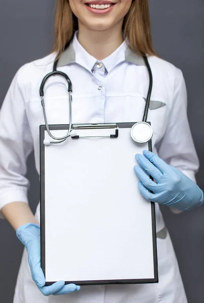 Joven doctora sonriente, enfermera con tableta de papel. Lugar para texto, imagen recortada — Foto de Stock