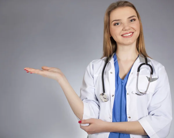 Young  attractive woman doctor holds  palm horizontal and smile. — Stock Photo, Image