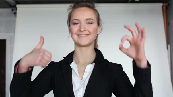 Дівчина починає модель пози в фотостудії, показувати палець вгору . — стокове відео