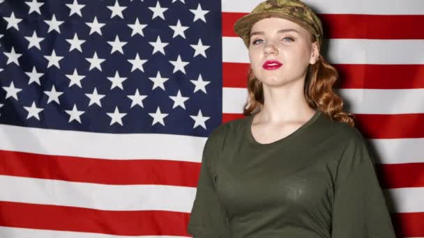 Leende flicka soldater med makeup salute framför oss flagga — Stockvideo