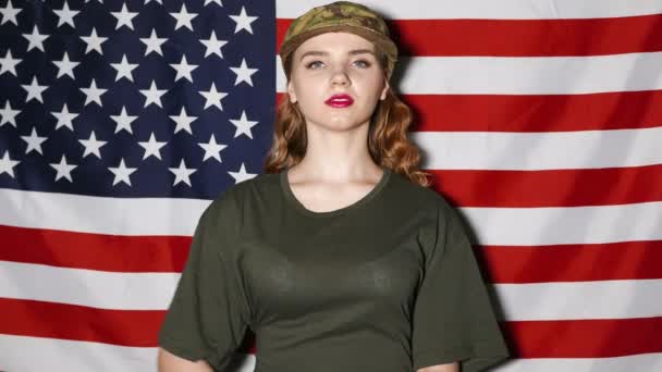 Young woman  soldiers  with makeup salute in front of US flag — Stock Video