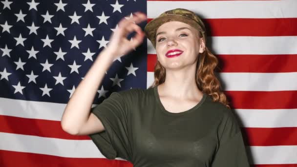 4K.Young soldados menina na frente da bandeira dos EUA com sinal OK — Vídeo de Stock