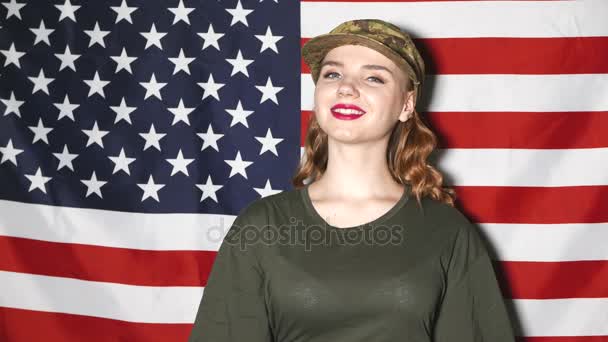 4 k. στρατιώτες νεαρό κορίτσι με το μακιγιάζ να σταθεί και να χαμογελά μπροστά μας σημαία — Αρχείο Βίντεο
