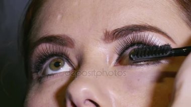  Fotoğraf çekme önce genç kadın modeli 4 k. makyaj işlemidir. Kirpik üzerinde çalışmak 