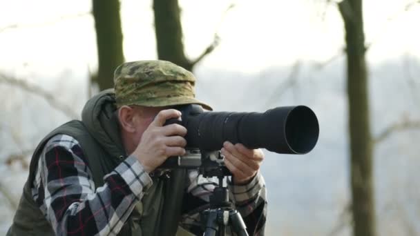 4k. Gezicht van landschapsfotograaf werkt met camera in de herfst hout — Stockvideo