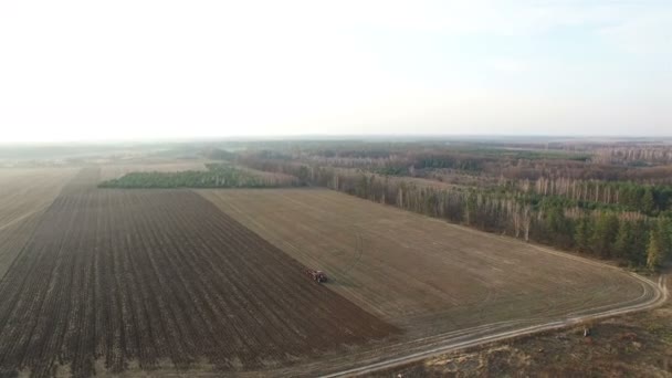 4K Aerial. Tractor plough field in agriculture area, lowering of  camera — Stock Video