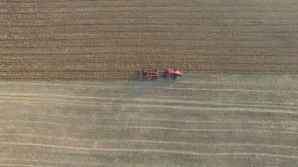 Aérea 4K. Campo de arado del tractor en la zona agrícola, vista superior, vuelo lateral — Vídeos de Stock