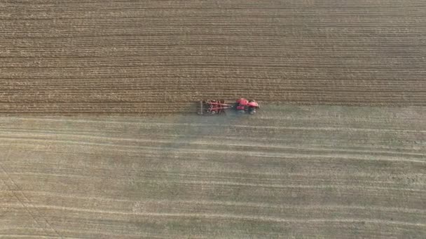  4K Aerial. Champ de charrue de tracteur dans la zone agricole, vue de dessus, vol latéral 