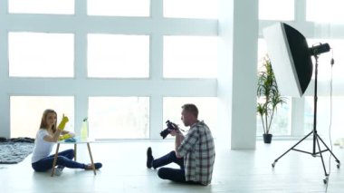    PhotoStudio sahne arkasında. Adam fotoğrafçı açıklamak pozlar kadın modeli ev kadını gibi. 