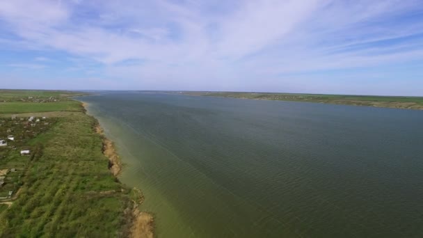 4K Aerial. Over spring field and village with lake — Stock Video