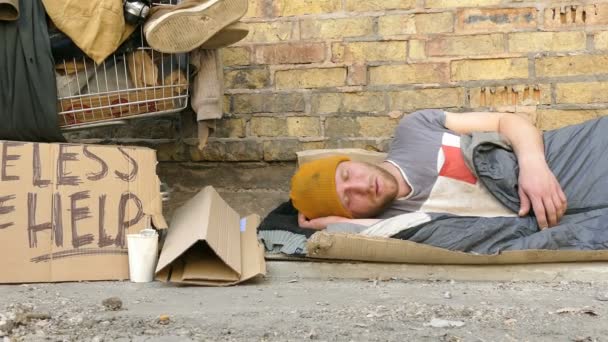 4K. Hombre mendigo sin hogar con carro de dormir cerca de la pared. Slider disparar — Vídeo de stock