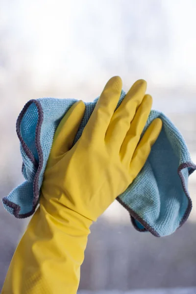 Mano femenina en guante amarillo con trapo en cristal de ventana — Foto de Stock