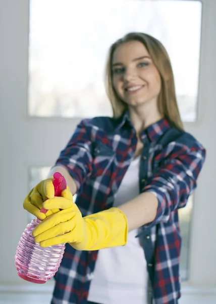 Chica sonriente sostiene la botella de detergente en las manos. Cara borrosa — Foto de Stock