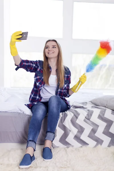 Mujer joven ama de casa hacer selfie por teléfono inteligente y sonrisa — Foto de Stock