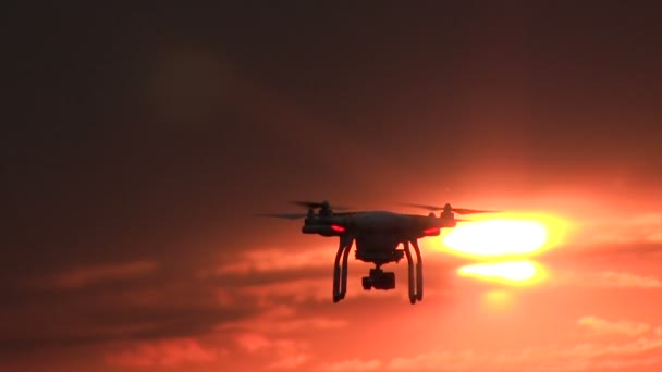 Drone volante di fronte al tramonto cielo rosso. Tecnologie moderne e natura — Video Stock