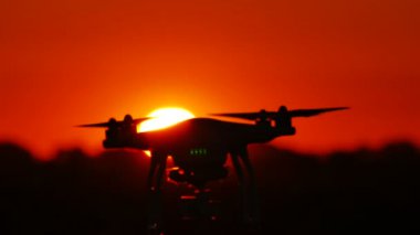 Yavaş silüeti dron günbatımı kırmızı gökyüzü önünde uçan. Modern teknolojiler 