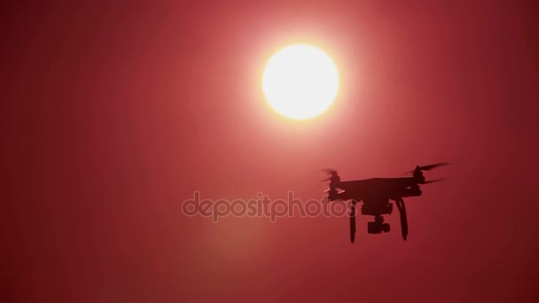 Silhouet van langzame vliegende drone voor rode avondrood. Moderne technologieën — Stockvideo
