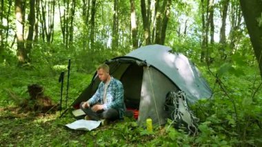  4 k. adam turist bahar orman çadırda yakınındaki smartphone ve kağıt harita ile. 