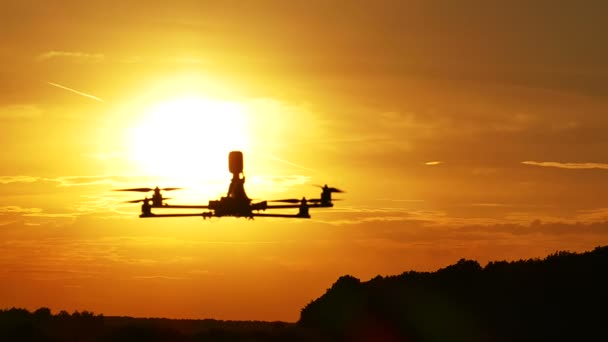 Drone vuela lento frente al cielo naranja al atardecer. Movimiento lento — Vídeos de Stock