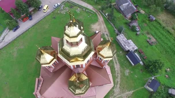 4K. Aerial. Vola intorno alla Chiesa ortodossa con cupole dorate nella piccola città — Video Stock