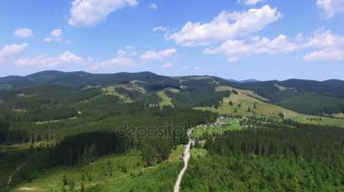 4k. Hava manzara. Dağlar, orman, çayır, mavi gökyüzü ve küçük bir köy