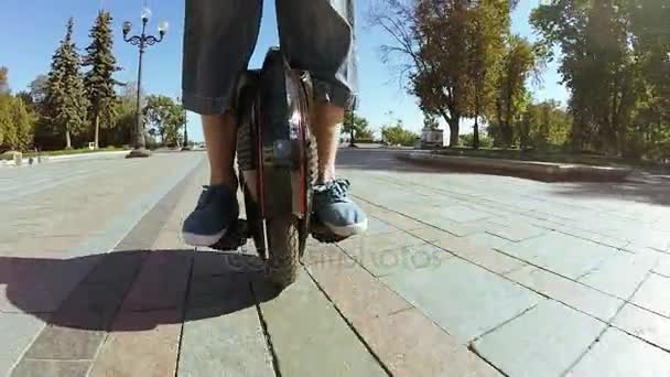 Man riding mono wheel personal electrical transport in autumn city park. POV  view — Stock Video