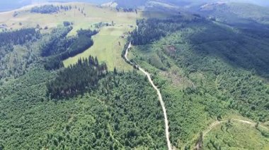 4k. Hava dağ manzarası. Tepeler ve toprak yol üzerinde uçmak