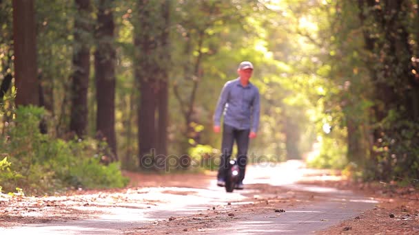 Transporte pessoal eléctrico. Homem montando mono roda no outono parque estrada . — Vídeo de Stock