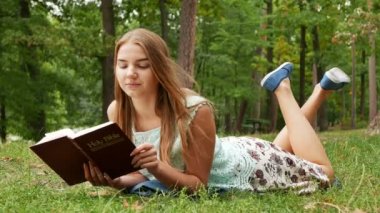 4 k. Serme ince kız İncil'de park ve gülümseme okuyun. Rüzgarlı bir gün 