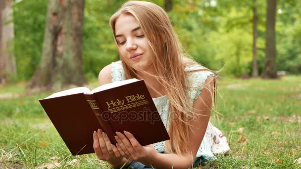 Deitado Menina Com Bíblia Parque — Vídeo de Stock