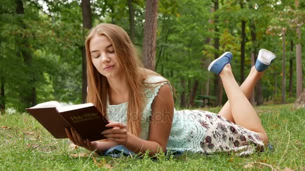 Colocando Chica Delgada Leer Biblia Parque Día Ventoso — Vídeo de stock