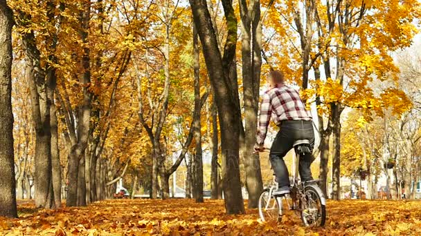 Lassú Mozgás Ember Lovagolni Kerékpár Sárga Levelek Őszi Parkban — Stock videók