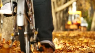 Ağır çekim. Bisiklet ağaçları ile sonbahar şehir parkında. Sağlıklı yaşam