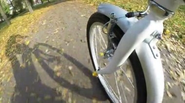 Kamera görünümü filme bir nokta. Sonbahar Şehir Parkı üzerinde tekerlek modern bisiklet sürmek