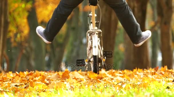 秋天公园的自行车上抬起腿的快乐人 — 图库视频影像