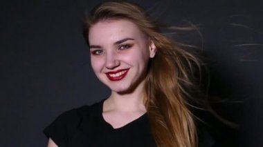 Genç dalgalar saçlı güzel kız gülümseyerek kameraya bak. Ağır çekim