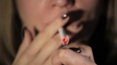 Kadın ışıklar sigara. Aşırı yakın çekim, bulanık yüz