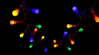 Yavaş yavaş yanıp sönen koyu arka plan üzerinde iki garland ışıklar