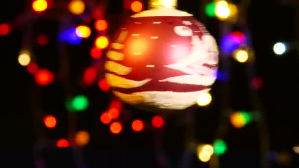 Красный Игрушечный Шар Вращается Против Праздничных Огней Символ Рождества Нового — стоковое видео